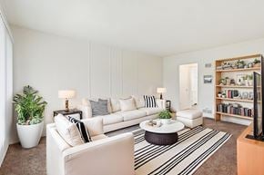 Inglewood apartment for rent - A living room with a white couch, a coffee table, and a potted plant.