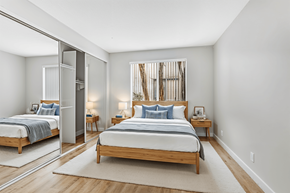 North Hollywood apartment for rent - A bedroom with a large bed and a mirror on the wall.