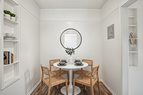 Los Angeles apartment for rent - A small dining room with a round mirror and a table with chairs.