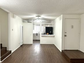 Westwood apartment for rent - an empty living room with a ceiling fan and a kitchen