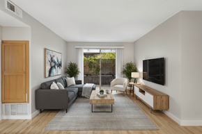 North Hollywood apartment for rent - A living room with a grey couch, a coffee table, a chair, and a painting on the wall.