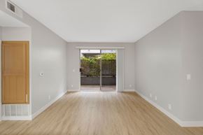 North Hollywood apartment for rent - A room with a wooden door and a window with a view of a fence and trees.