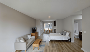 Van Nuys apartment for rent - A modern bedroom with a white bed and wooden floors.