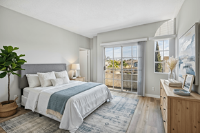 Los Angeles apartment for rent - A bedroom with a large bed and a view of the outside through the window.