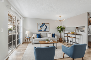 Los Angeles apartment for rent - A living room with a couch, two chairs, and a dining table.