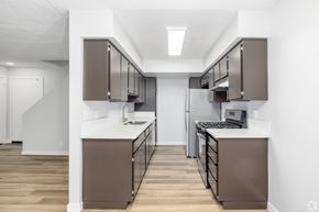 Van Nuys apartment for rent - A modern kitchen with brown cabinets and a white countertop.