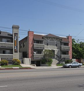 Van Nuys apartment for rent - A car is parked on the street in front of a building.