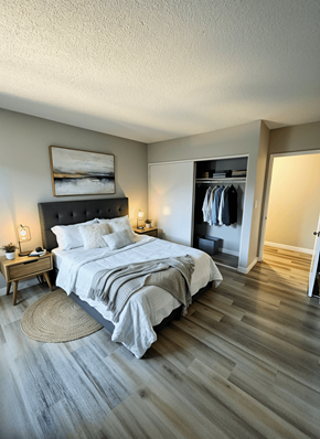 Van Nuys apartment for rent - A bedroom with a large bed and a wooden floor.