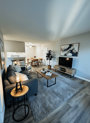 Van Nuys apartment for rent - A living room with a grey couch, a wooden coffee table, and a television.