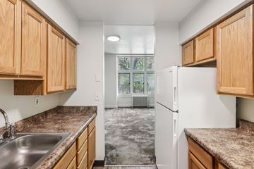 New Kensington apartment for rent - A kitchen with wooden cabinets and a white refrigerator.