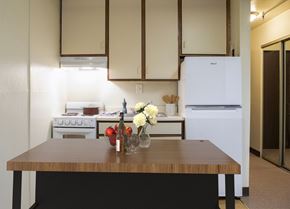 North Versailles apartment for rent - A kitchen with a table in front of a stove and a refrigerator.