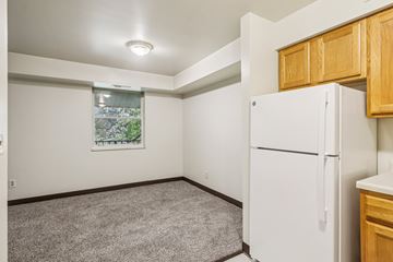 Turtle Creek apartment for rent - A white refrigerator in a kitchen with wooden cabinets.