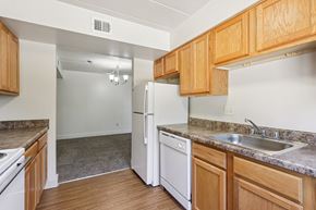 White Oak apartment for rent - A kitchen with a white refrigerator and wooden cabinets.