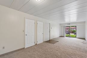 Swissvale apartment for rent - A room with white walls and carpeted floor with a sliding glass door.