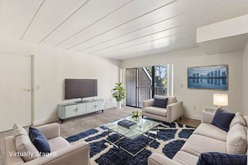 White Oak apartment for rent - A living room with a white couch, a glass coffee table, and a painting on the wall.