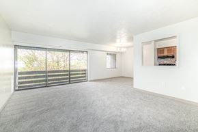 Elizabeth apartment for rent - A spacious room with a grey carpet and a sliding glass door leading to a balcony.