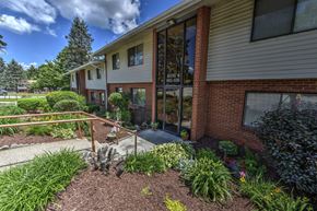 White Oak apartment for rent - A flowering garden in front of the entrance to one of the apartment buildings at  White Oak Farms.