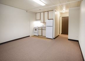 North Versailles apartment for rent - A small kitchen with white appliances and brown carpeting.