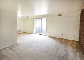 North Huntington apartment for rent - A large, empty room with a carpeted floor and a sliding glass door leading to a balcony.