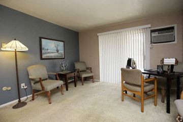 Michigan City apartment for rent - a living room with several chairs and a desk