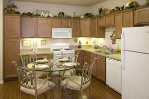 Avon apartment for rent - A kitchen with a table set for two and a white refrigerator.