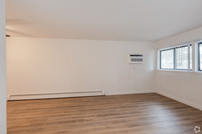 Michigan City apartment for rent - Empty room with wooden floor and white walls.