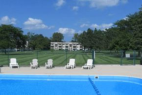 Michigan City apartment for rent - A pool with chairs around it and a building in the background.