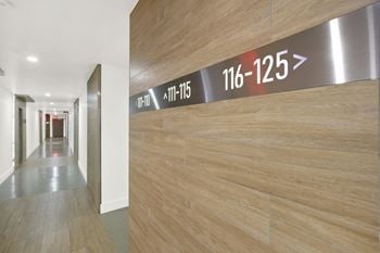 A long hallway with a wall that has a sign that says 116-125.