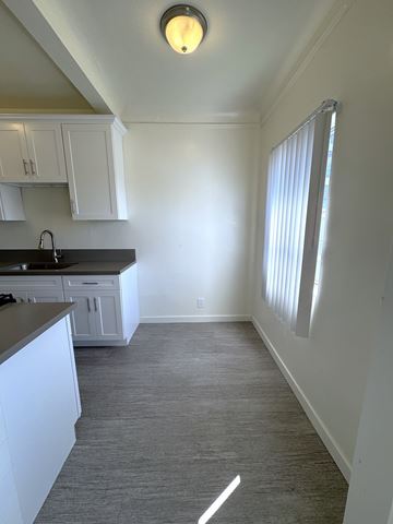 Los Angeles apartment for rent - A kitchen with white cabinets and a black countertop.
