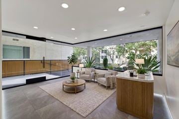 Los Angeles apartment for rent - A modern living room with a wooden coffee table and a large window.