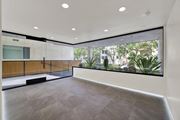 Los Angeles apartment for rent - A spacious room with a grey floor and a large window overlooking a garden.