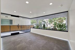Los Angeles apartment for rent - A spacious room with a grey floor and a large window overlooking a garden.
