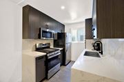 Los Angeles apartment for rent - A modern kitchen with dark brown cabinets and white countertops at Westwood Riviera Apartments, Los Angeles, California