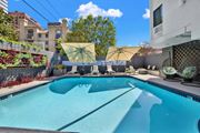 Los Angeles apartment for rent - A swimming pool with a yellow umbrella and a white chair. at Westwood Riviera Apartments, Los Angeles