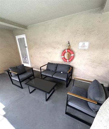 Los Angeles apartment for rent - A living room with black furniture and a life preserver on the wall.
