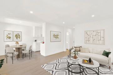 Los Angeles apartment for rent - A living room with a white couch, a dining table with chairs, and a rug on the floor.