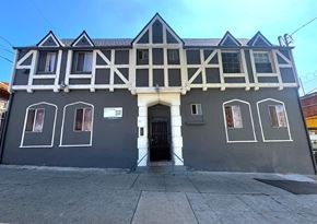 Los Angeles apartment for rent - A building with a black and white facade has a black door and windows.