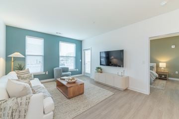 Richmond apartment for rent - A living room with a white couch and a wooden coffee table.