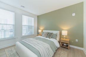 Richmond apartment for rent - A bedroom with a large windows, LVT flooring, tall ceilings and modern finishes.