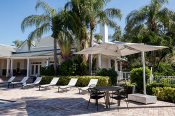 A patio with chairs and an umbrella in front of a house