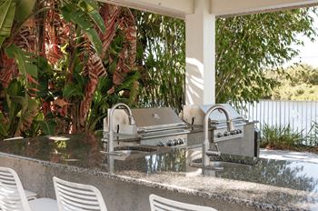 An outdoor kitchen with a grill and a sink