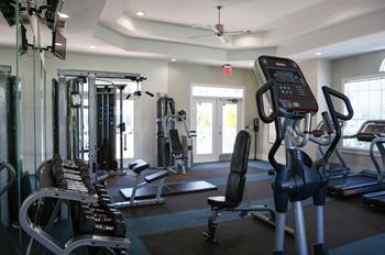 A gym with various cardio machines and weights