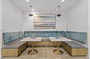 Cranberry Township apartment for rent - A modern dining area with a wooden table and blue cushioned booths.