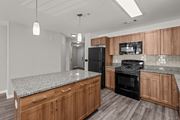 Stratford apartment for rent - A kitchen with wooden cabinets and a black refrigerator.