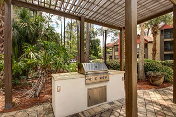 A covered patio with a gas grill