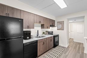 Clifton Park apartment for rent - Modern kitchen with black appliances and wood cabinets at The Crossings at Halfmoon Apartments, Clifton Park, NY
