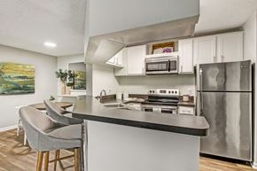 Jacksonville apartment for rent - a kitchen with stainless steel appliances and a counter with chairs at Timberwalk at Mandarin Apartment Homes, Florida, 32257