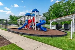 Millsboro apartment for rent - A playground with a blue and red slide and a white canopy.