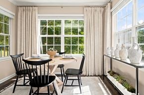 Groton apartment for rent - A dining room with a table set for two and a window with curtains.