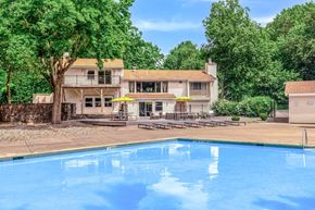 Clifton Park apartment for rent - Pool deck with lounge chairs and resident building at The Northway at Clifton Park Apartments, New York